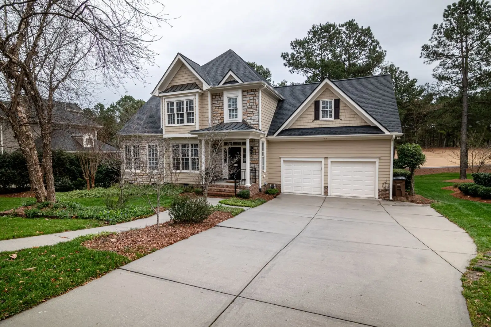 Two-story home with white garage doors
